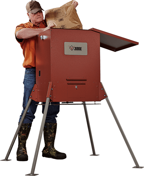 A person filling a low-profile Judge feeder from the ground